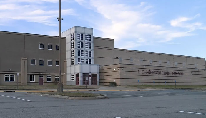 Exterior view of a high school building under a clear sky. Exterior view of a high school building under a clear sky.