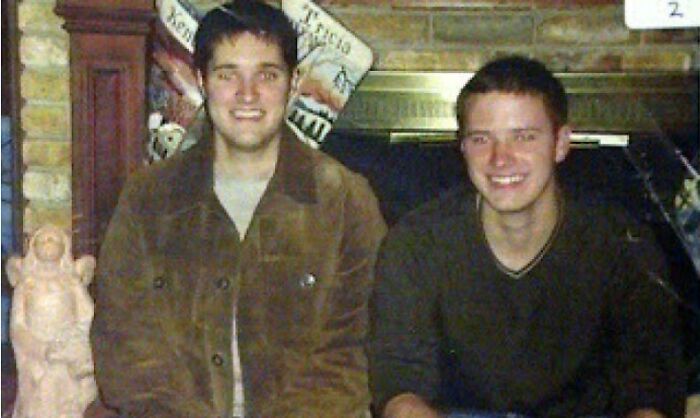 Two men seated by a fireplace, smiling, with a mysterious aura. Creepy photo with an intriguing backstory.