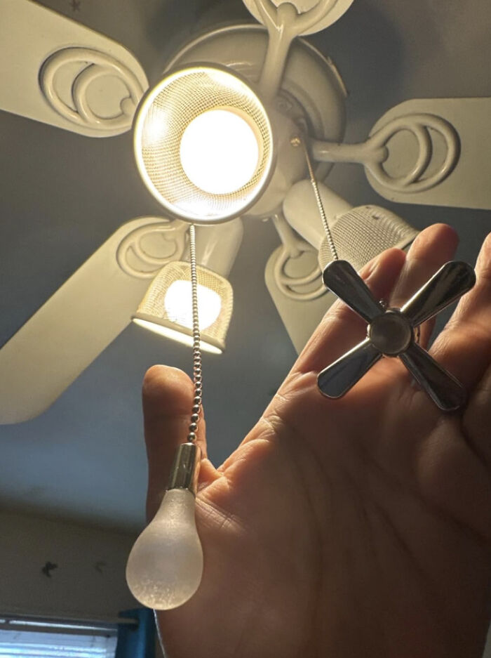 Ordinary-looking ceiling fan with extraordinary bulb and fan chain design in a close-up view.