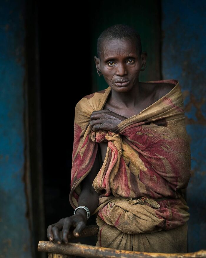 Person in traditional attire, standing with a thoughtful expression, highlighting cultural beauty.