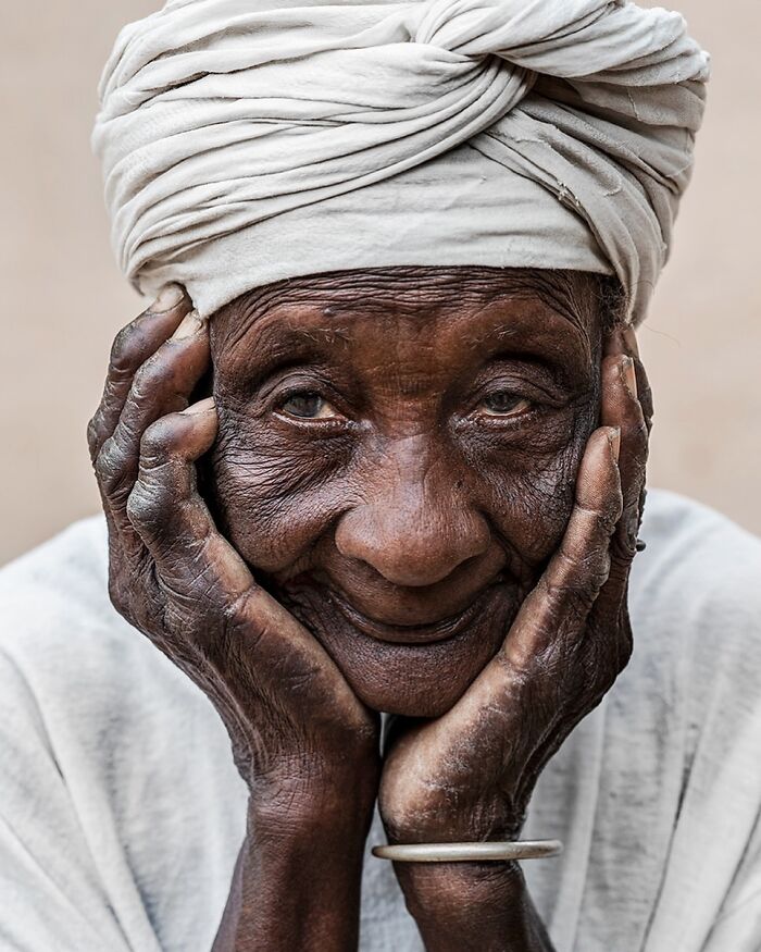 Elderly person with a warm smile and white turban, symbolizing cultural beauty worldwide.