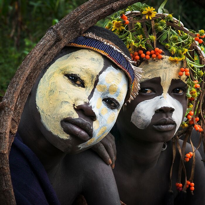 Two people with vibrant face paint and traditional adornments, capturing the beauty of cultures around the world.