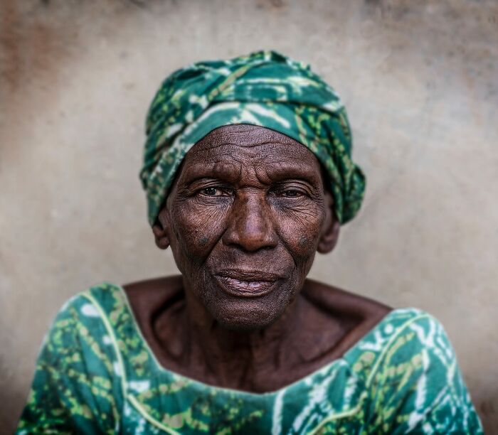 Elderly woman in traditional green attire, reflecting cultural beauty and diversity.