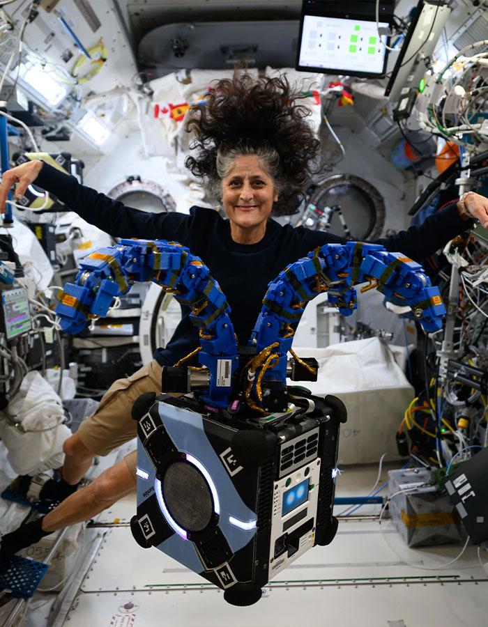 Astronaut floating in space station, hair defying gravity, showcasing effects of nine months in space.