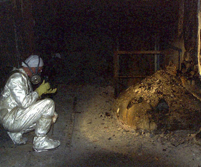 A person in protective gear inspects a dark, eerie scene, representing creepy photos with haunting histories.