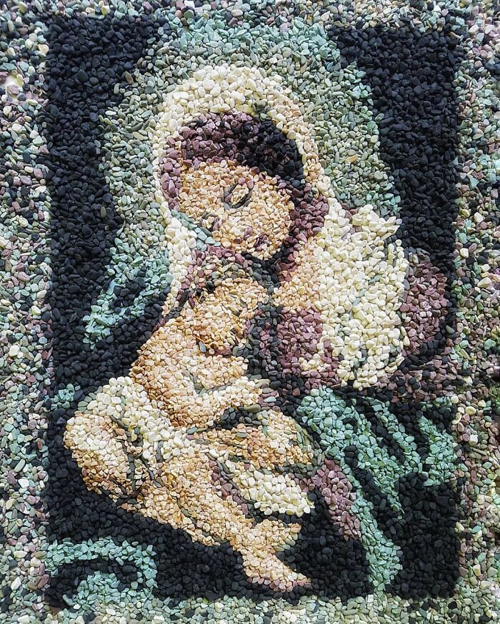 Intricate temporary mosaic made of stones and pebbles by British artist, depicting a serene figure in a colorful design.