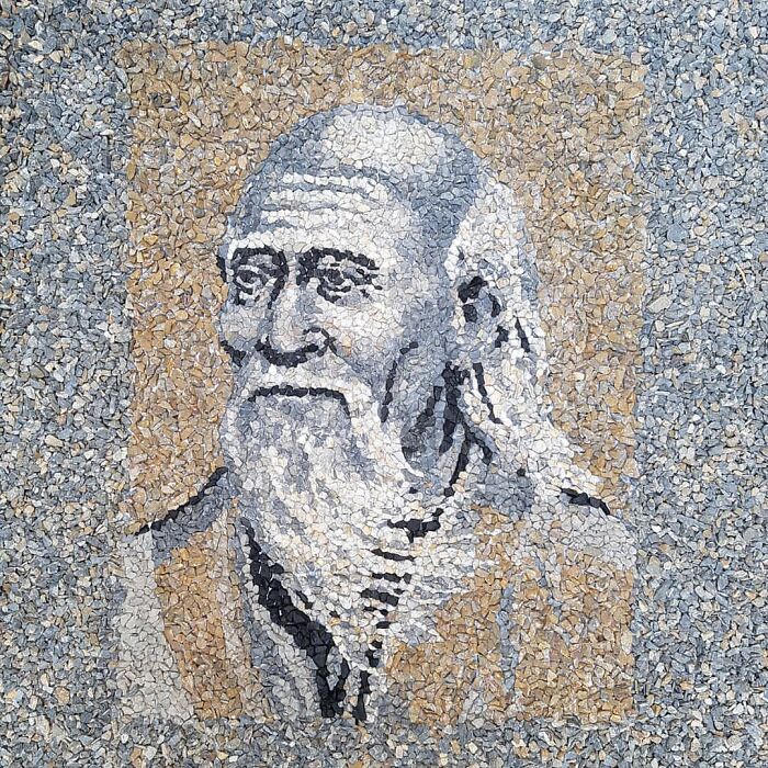 Stone and pebble mosaic depicting a detailed portrait on a textured surface.