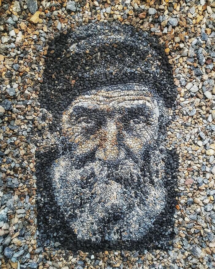 Stone and pebble mosaic resembling a man's face, created by a British artist.