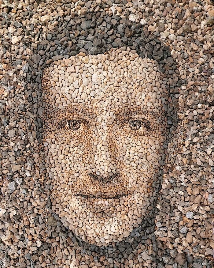 Intricate mosaic portrait of a face made from stones and pebbles by a British artist.
