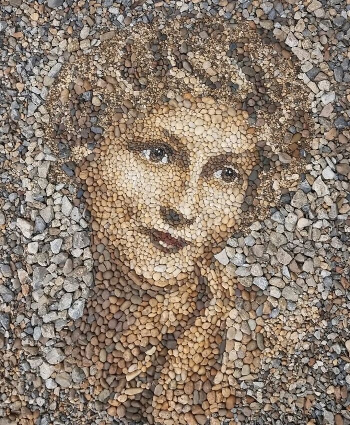 Intricate mosaic of a woman's face made with stones and pebbles by a British artist.