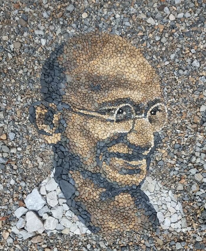 Stone and pebble mosaic portrait created by British artist, showcasing intricate design and temporary artistry.