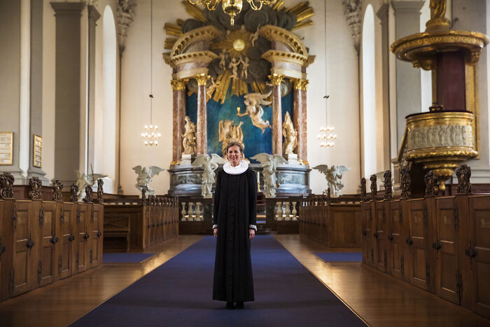 A woman stands in a grand church interior, challenging societal norms.