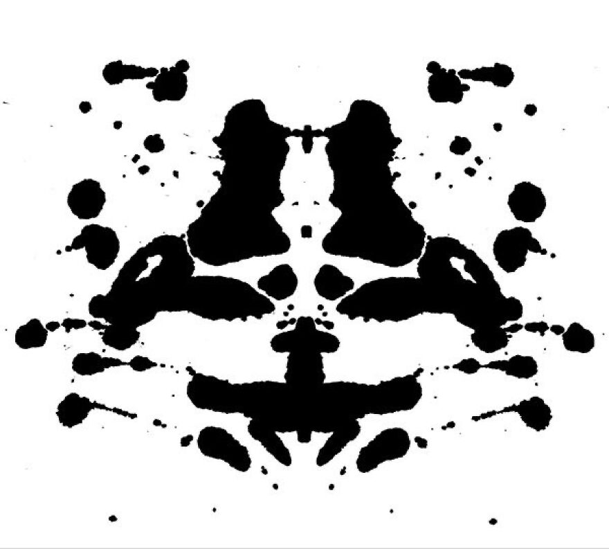 Rorschach inkblot test pattern, black symmetrical shapes on white background.