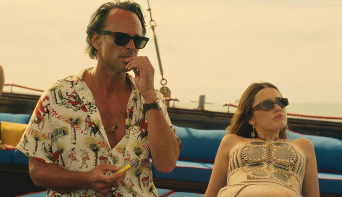 Aimee Lou Wood, in sunglasses, relaxes on a boat, exuding confidence amidst the White Lotus setting.