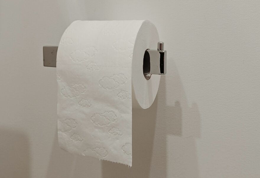 Toilet paper roll on a wall mount in a bathroom, highlighting showering at night for better hygiene.
