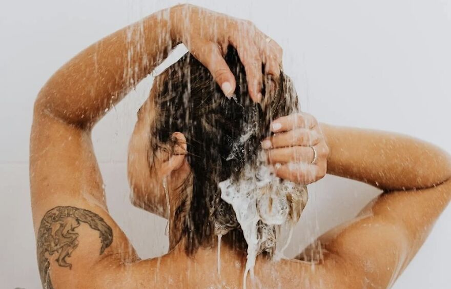 Person enjoying a nighttime shower, emphasizing the benefits of showering at night with water streaming down their back.