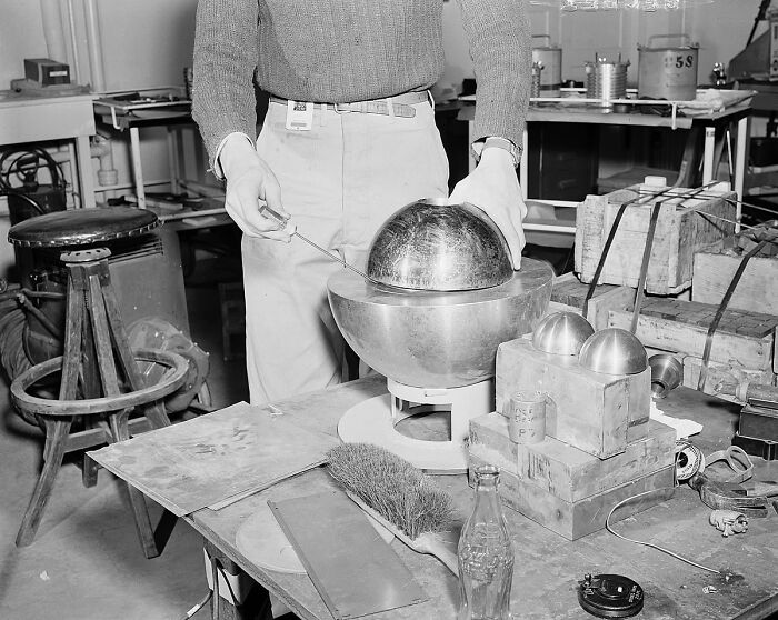 A person conducting an experiment with metal spheres in a laboratory, related to creepy dark histories.