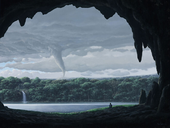 Man sitting at a cave entrance, gazing at a landscape with a waterfall, forest, and distant tornado; meditative art scene.