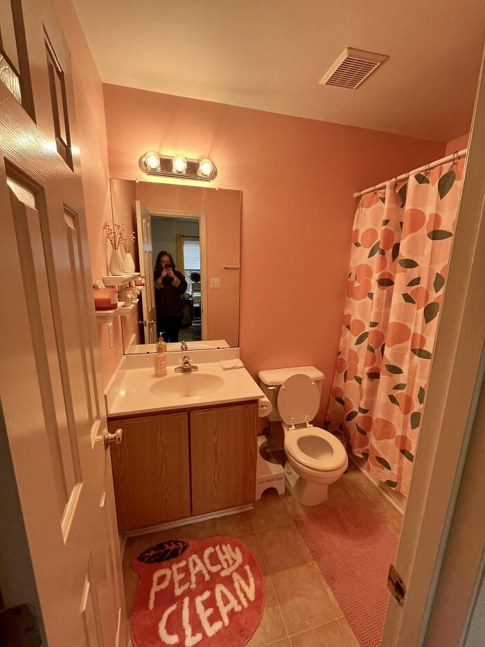 Bathroom interior with peach-colored walls and decor, illustrating poorly-aging interior design trends to avoid.
