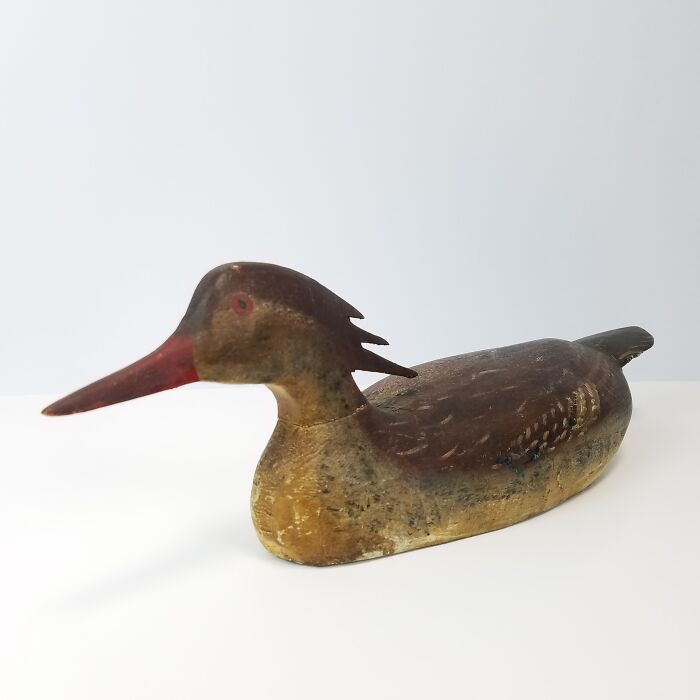 Vintage wooden duck decoy with worn paint, collectible item.