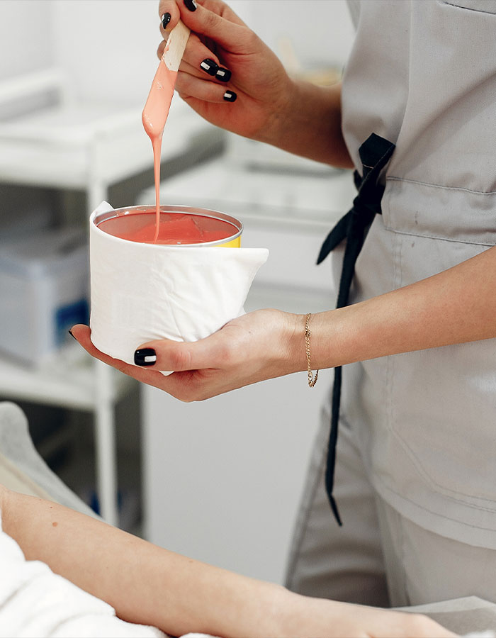 A person preparing wax, highlighting the cultural moment of the pubic hair debate.
