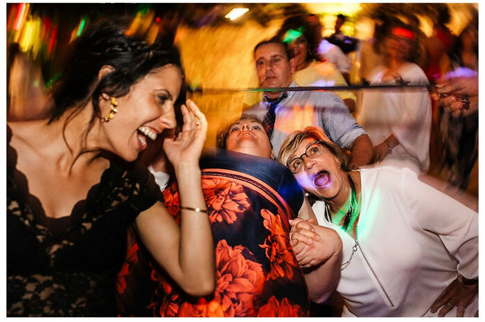Wedding photograph by Jordi Tudela capturing joyful guests dancing and laughing in a festive atmosphere.