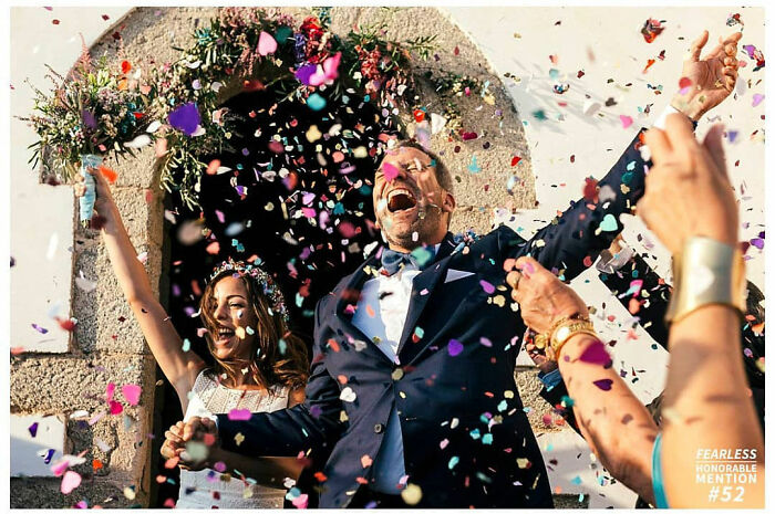 Joyful wedding moment with a couple celebrating under a shower of colorful confetti.