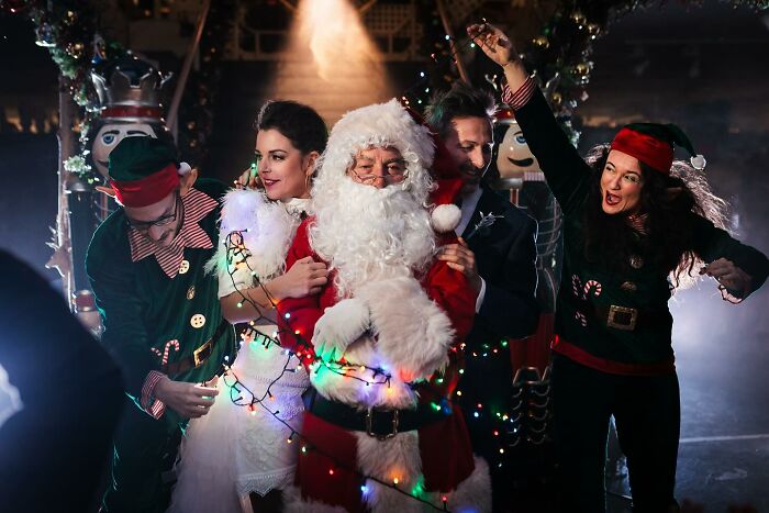 Santa and festive group in a lively Christmas-themed wedding photo, capturing precious moments of love.