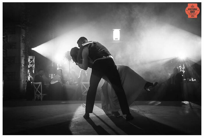 A couple shares a romantic dance at their wedding, captured in a stunning black and white photograph by Jordi Tudela.