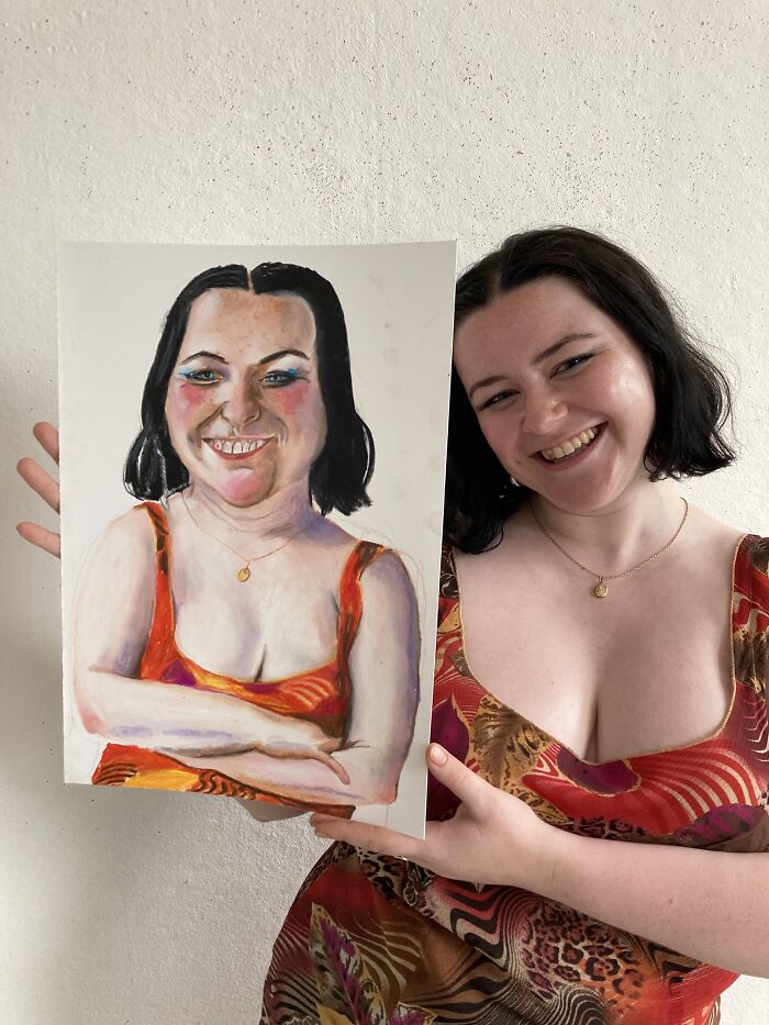 British artist showcases expressive portrait, featuring a smiling woman holding her own painted likeness in a colorful dress.