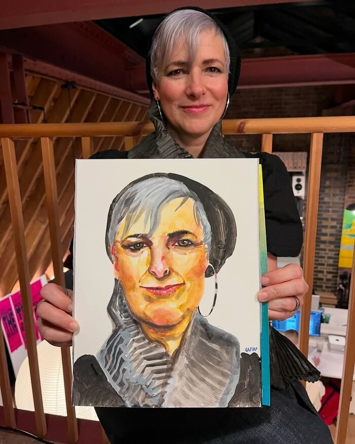 British artist with expressive portrait, showcasing their unique artistic style in a warm, wooden studio setting.