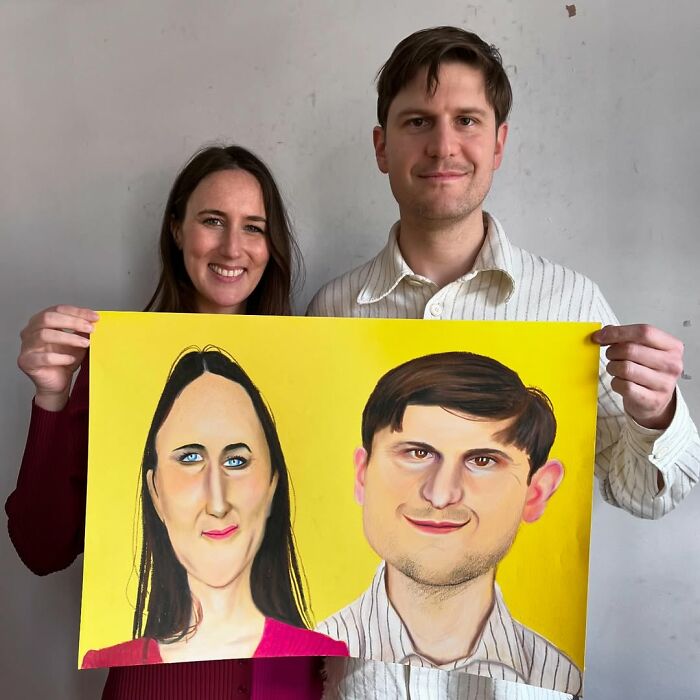 Two people holding a colorful and expressive portrait, demonstrating British artist's unique style.