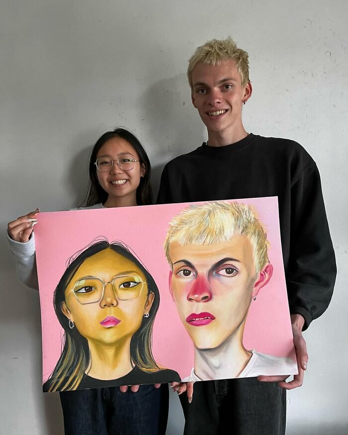 British artist holding expressive portrait painting with a friend, showcasing vibrant and emotional artistry.