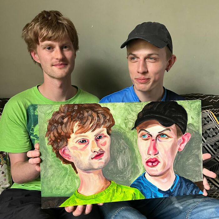 Two men holding an expressive portrait painting, showcasing the distinctive style of a British artist.