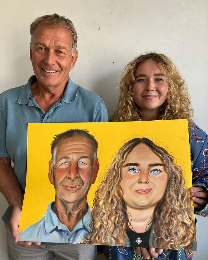 Man and woman holding expressive portrait by British artist, highlighting vibrant colors and detailed features.