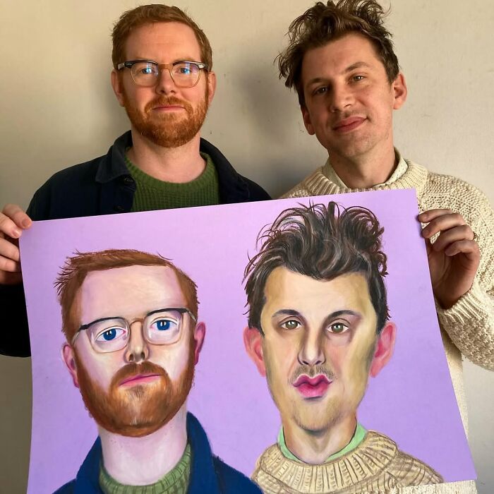 Two men holding a portrait they created, showcasing expressive art by a British artist.