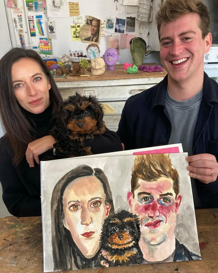 British artist with expressive portrait of a couple and their dog, smiling in a studio setting.
