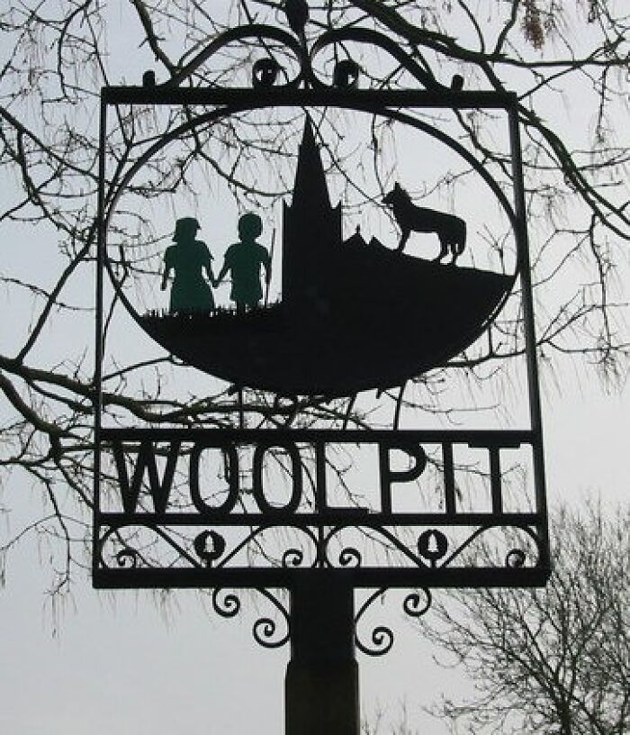 Woolpit village sign depicting folklore with children and a wolf silhouette, representing one of the cool Wikipedia articles.