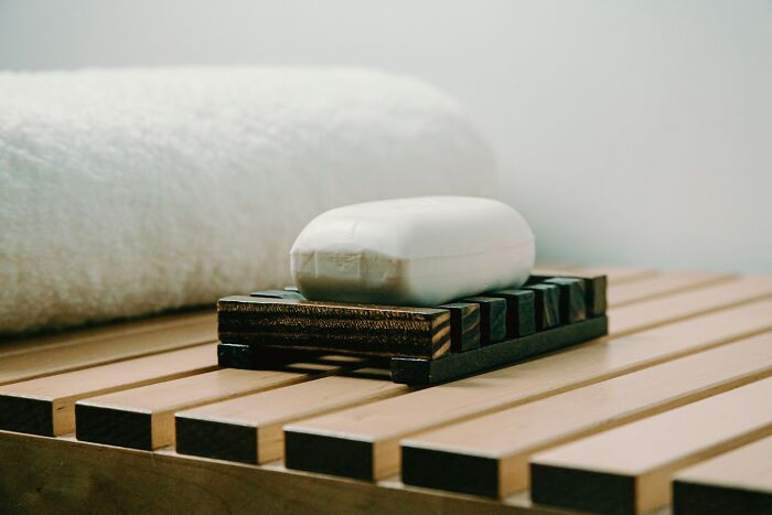 Bar of soap on a wooden soap dish, highlighting a lifetime supply in a minimalist bathroom setting.