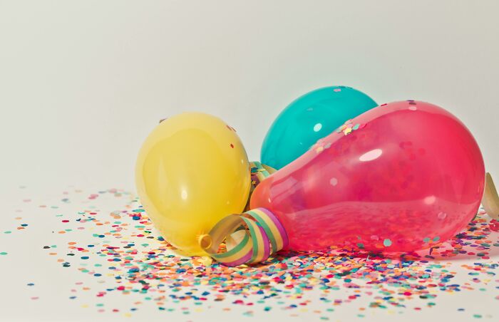 Colorful balloons and scattered confetti on a light background, showcasing vibrant traits.