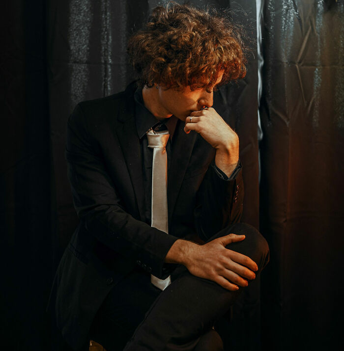 Man in a suit and tie sitting pensively, highlighting a potential wedding red flag moment.