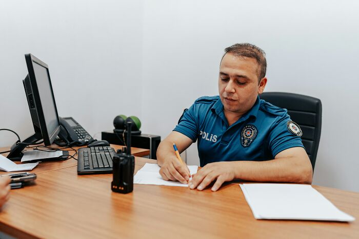 Man in uniform writing at a desk with a computer, illustrating a career outcome for "useless" degrees.
