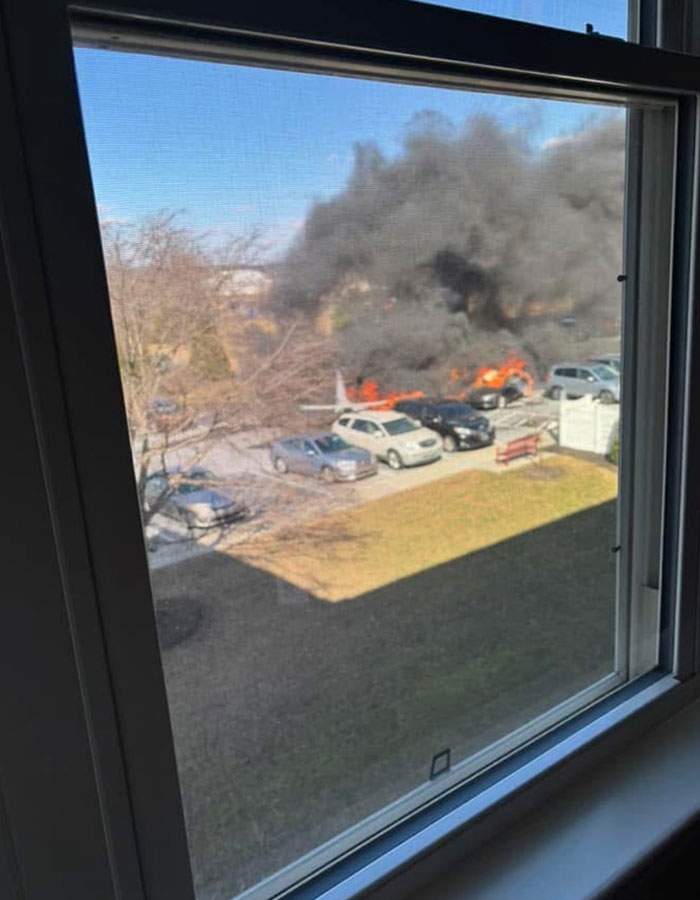 View of small plane crash-landing in Pennsylvania suburb, smoke rising from crash site. View of small plane crash-landing in Pennsylvania suburb, smoke rising from crash site.