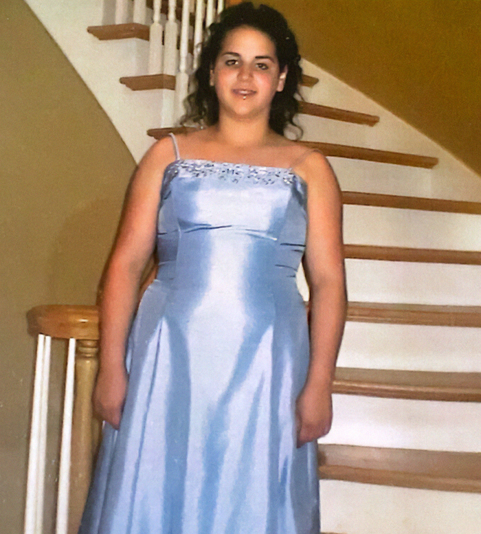 Woman in blue dress standing on stairs, related to dramatic Ozempic transformation story.