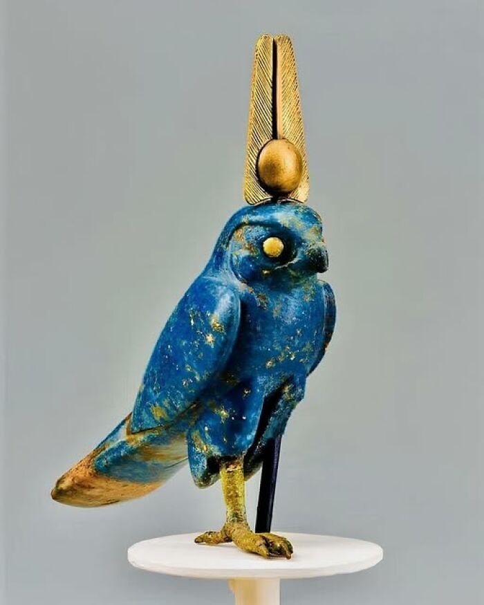 Ancient civilizations artifact: a blue falcon statue with gold accents on display.