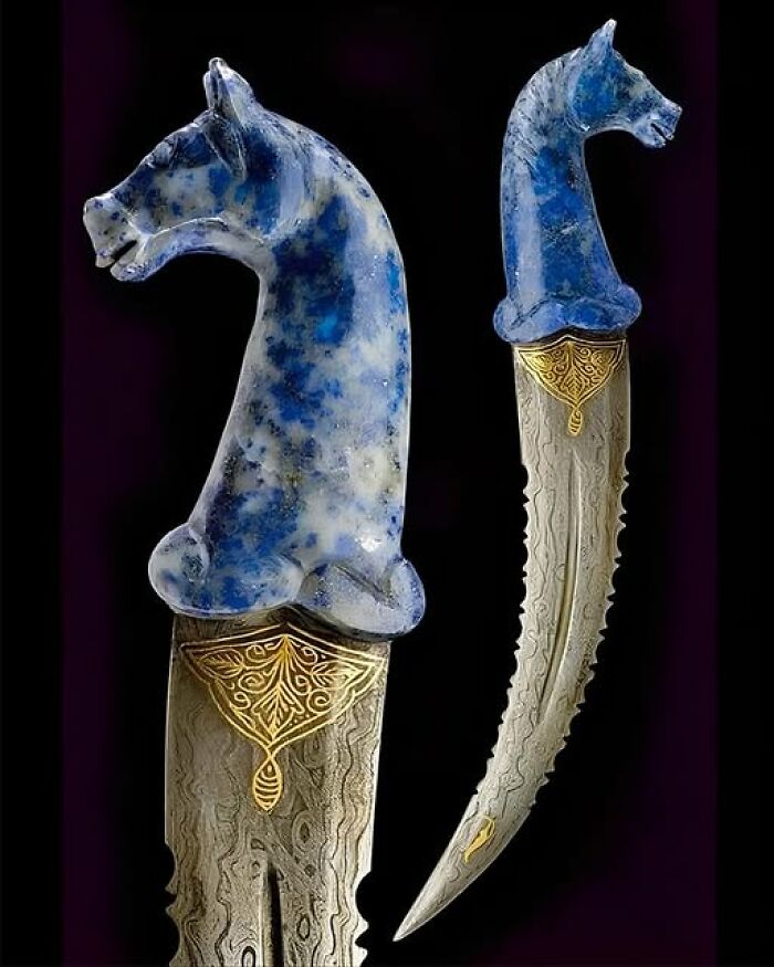 Ancient curved dagger with ornate blue horse head handle and intricate blade design.