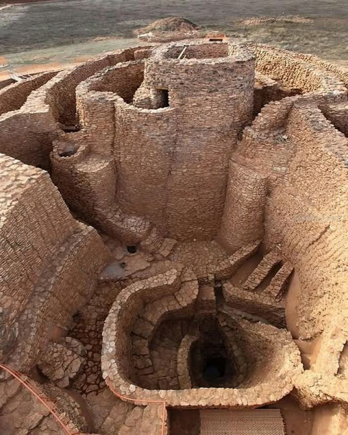 Ancient civilization stone ruins with intricate pathways and walls in a desert landscape.