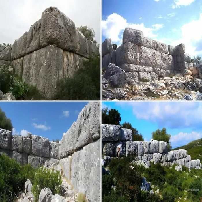 Ancient stone structures under a blue sky, showcasing impressive historical architecture amid natural surroundings.