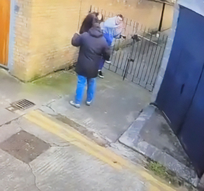 Irish horse carriage driver confronting tourists near a gated alley.