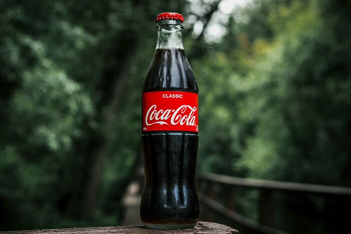 A classic Coca-Cola bottle outdoors, related to European news stories.